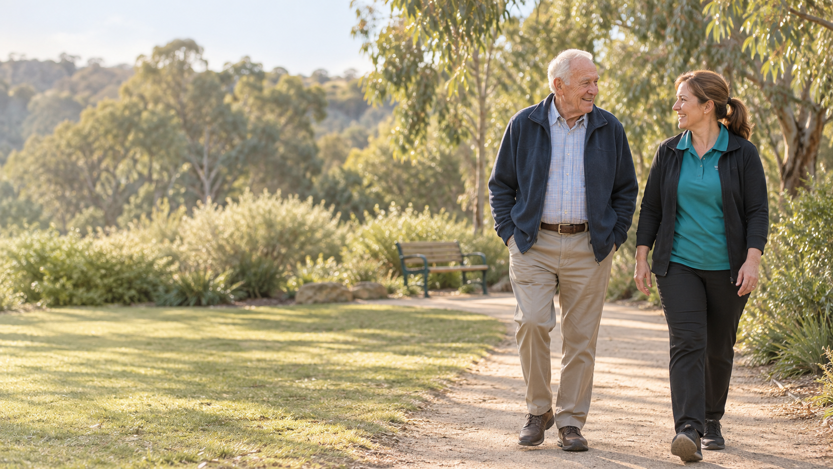 An older man enjoying a walk outdoors with a support worker